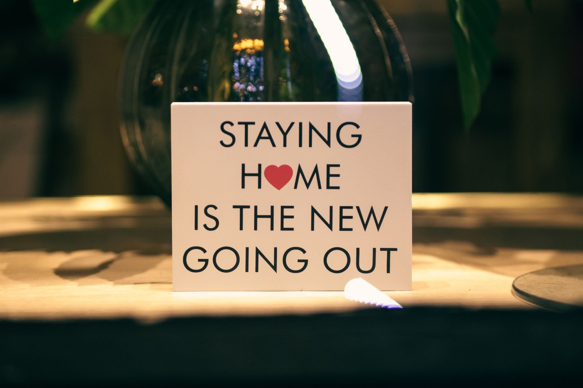 Warm living space with a decorative sign reading 'Staying Home is the New Going Out'